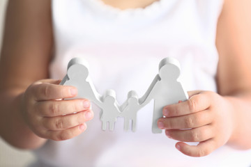 Child holding figure in shape of happy family, closeup. Adoption concept