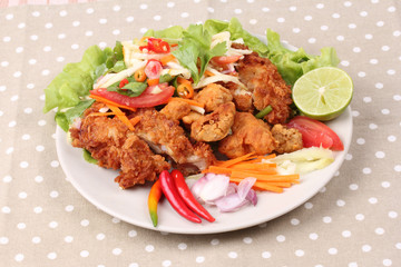 Spicy deep-fried chicken salad with roll green mango .