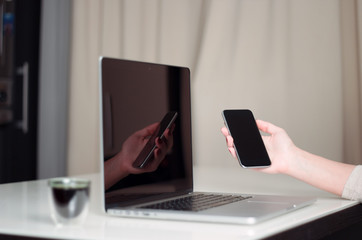 Woman is working with computer and smart phone