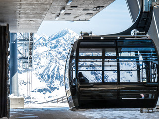 Lift leaving top of mountain station in winter alps panorama