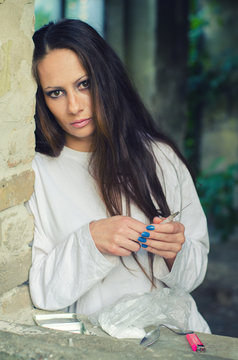 Young female drug heroin addict in abandoned building.