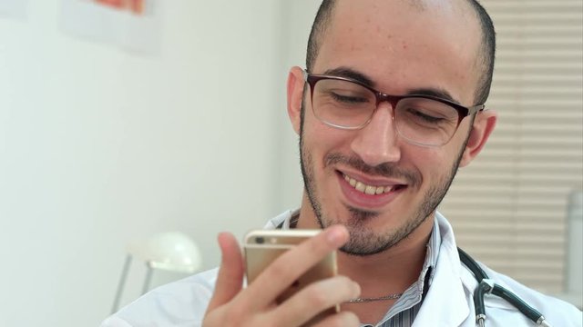 Medical worker checking his phone and laughing