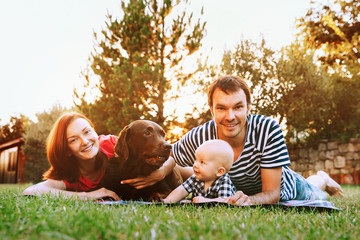 Family lying on the grass in the park together