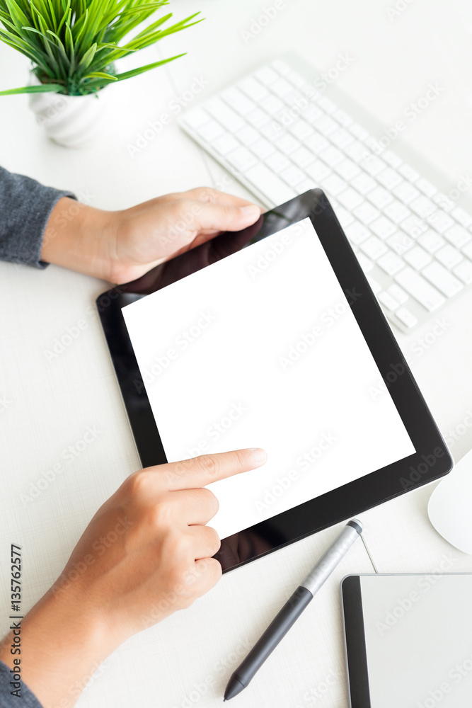 Aufkleber hand using digital tablet on desk vertical view