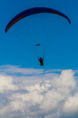 Naklejka na ściany i meble Paragliding with the eagles above the clouds, Pokhara Nepal.