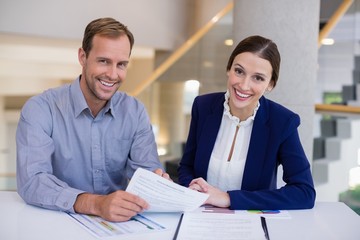 Businesswoman working at desk with colleague