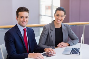 Happy business executives sitting at desk