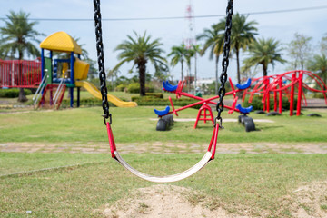 Obraz na płótnie Canvas Swings and colorful playground in park