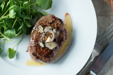 Grilled Steak with Truffles and Greens on White Dish