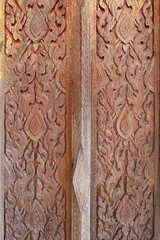 Traditional thai style carve on the wooden door.