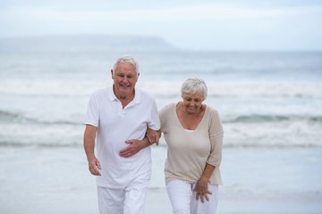 Senior couple walking together on the beach