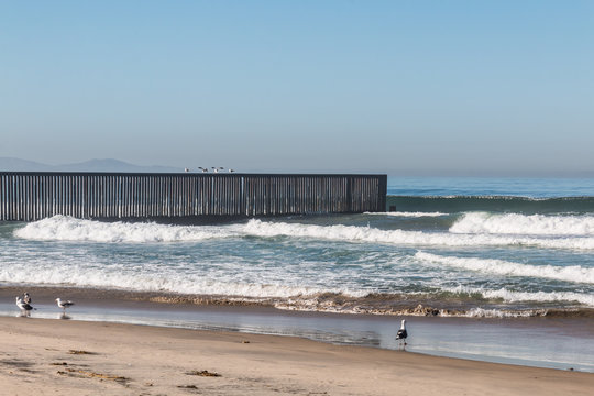 An empty beach at Border Field State Park, with the international border separating San Diego, California from Tijuana, Mexico in the background.