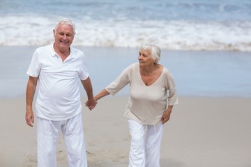 Senior couple walking together on the beach