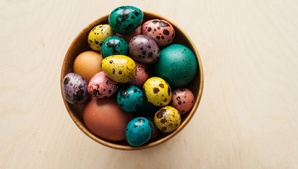 Easter. Colorful eggs in a wooden bowl  on wooden background