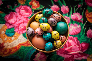 Easter. Colorful eggs in a wooden bowl  on a background of patte