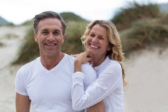 Smiling mature couple standing together on the beach