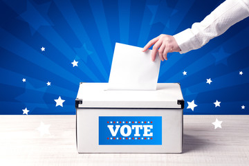 hand with ballot and wooden box