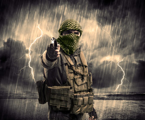 Dangerous armed terrorist with mask and gun in a thunderstorm wi