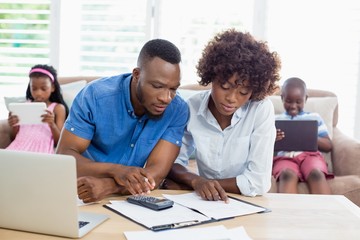 Couple sitting at table and calculating bills