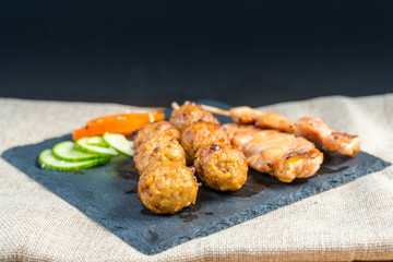tasty kabobs with vegetables on a slate plate