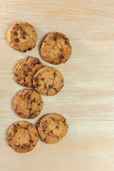 Pile of chocolate chips cookies on wooden board with copyspace