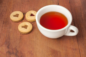 Tea cup and butter cookies with heart-shaped filling