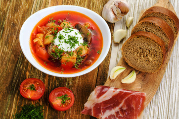 Red vegetable soup in the white plate and bread.