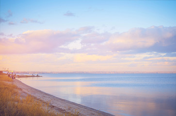 Fototapeta na wymiar Sky background on sunset, seafront. Nature composition. Panoramic sunset sky background. Taganrog Bay, Azov sea. Beautiful sunset over sea with reflection in water, majestic clouds in the sky.