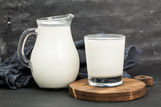 Pitcher and glass of milk. wooden stand. For your design.