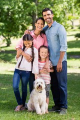 Obraz premium Portrait of happy family with their pet dog in park