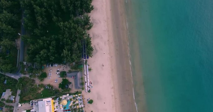Aerial footage. Flying close over tropical sandy beach and waves. Thailand. Phuket. Layan beach. 4K