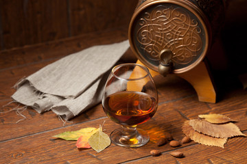 Glass of cognac on old wooden table