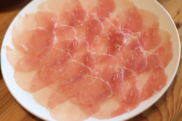 Raw pork sliced in white dish for shabushabu, Japanese recipe.