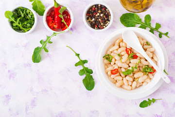 Boiled white beans in a bowl. Diet food. Healthy lifestyle. Sports nutrition. Flat lay. Top iew