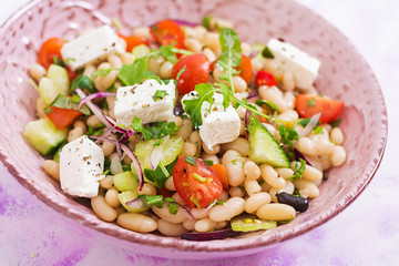 Salad of white beans, tomato, celery, cucumber, arugula, red onion and feta cheese in bowl. Diet food. Healthy lifestyle. Sports nutrition.