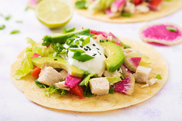 Healthy mexican corn tacos with boiled chicken breast, avocado and watermelon radish and yogurt dressing.