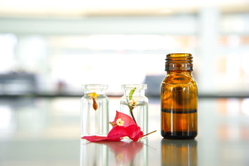 brown medical bottle with red flower vial with science laborator