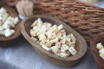 Cheese cubes in a wooden plate 