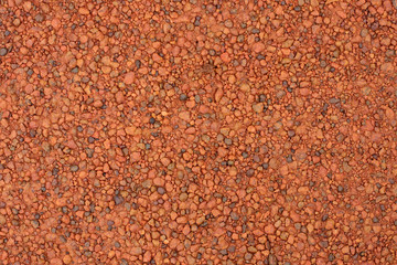 Red laterite gravel texture for background.