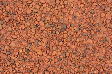 Red laterite gravel texture for background.
