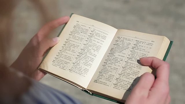 woman reading a book dictionary english for study