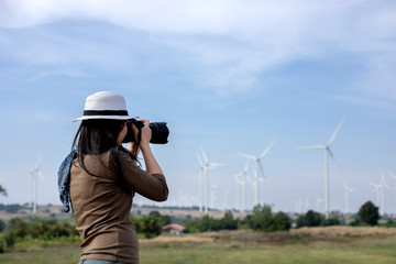 Obraz premium Women photographer holding a camera in the wind turbine for take