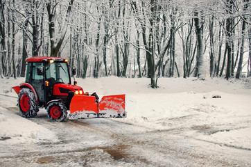 Excavator cleans the streets of snow in city. Winter time concept.