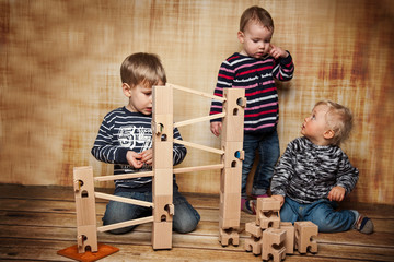 drei Kinder spielen mit der Kugelbahn