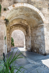 Fototapeta premium Old stone passage in stone wall