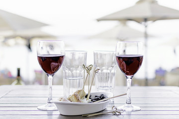 Two glasses of red wine with a snack on the beach