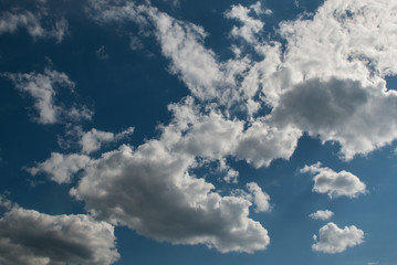 White fluffy clouds in the clear blue sky on a sunny day