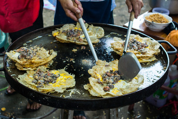 Fried mussel pancakes on frying pan - Thai food / Oysters fried in egg batter, Pan-fried crispy mussel with bean sprout, thai food