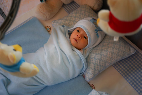 Asian Baby In The Bed Looking A Doll