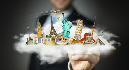 Businessman touching a cloud full of famous monuments with his f